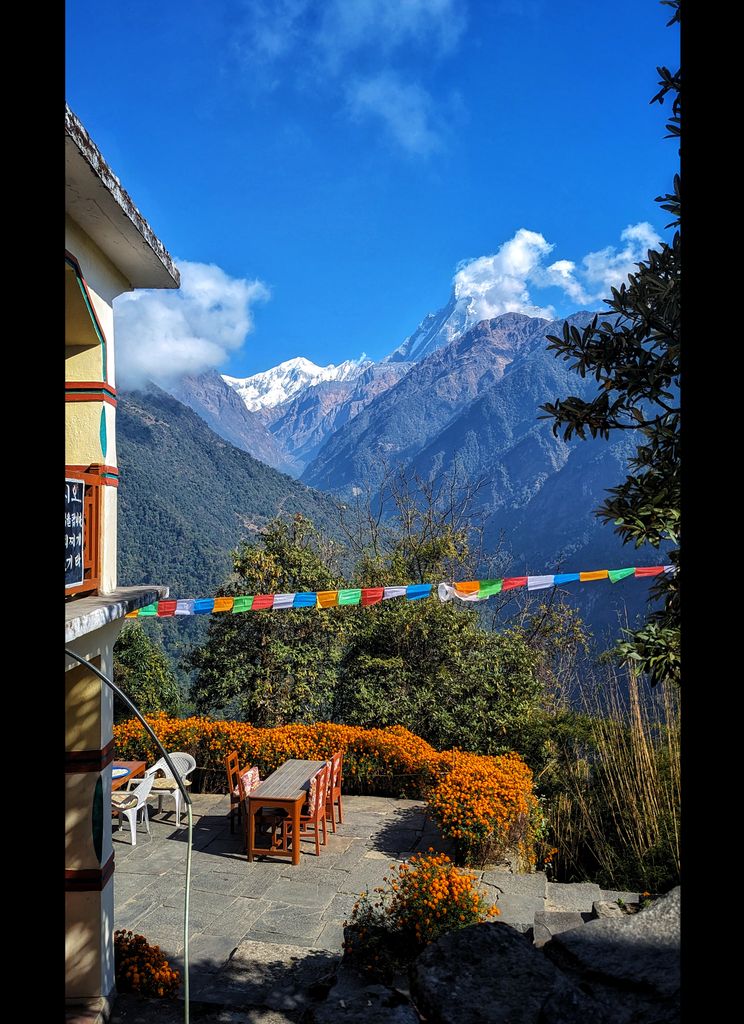 Scenic mountain view in Nepal featuring prayer flags and outdoor seating area. Perfect travel and nature imagery.
